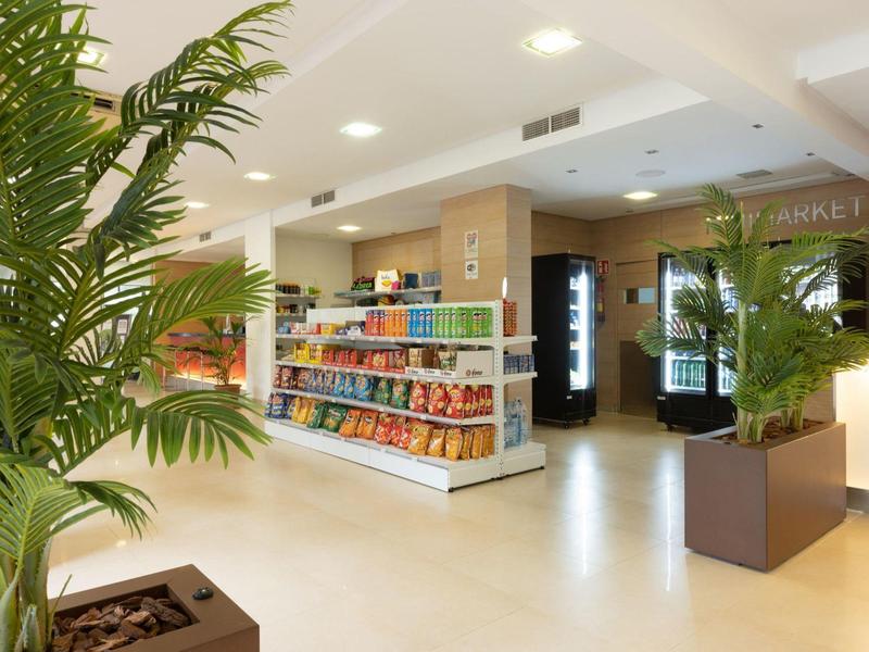 Bright hotel kiosk area with shelves filled with snacks and plants