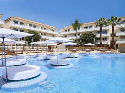 Großer Hotelpool mit runden Liegeinseln, Sonnenschirmen und mehrstöckigen Gebäuden im Hintergrund.