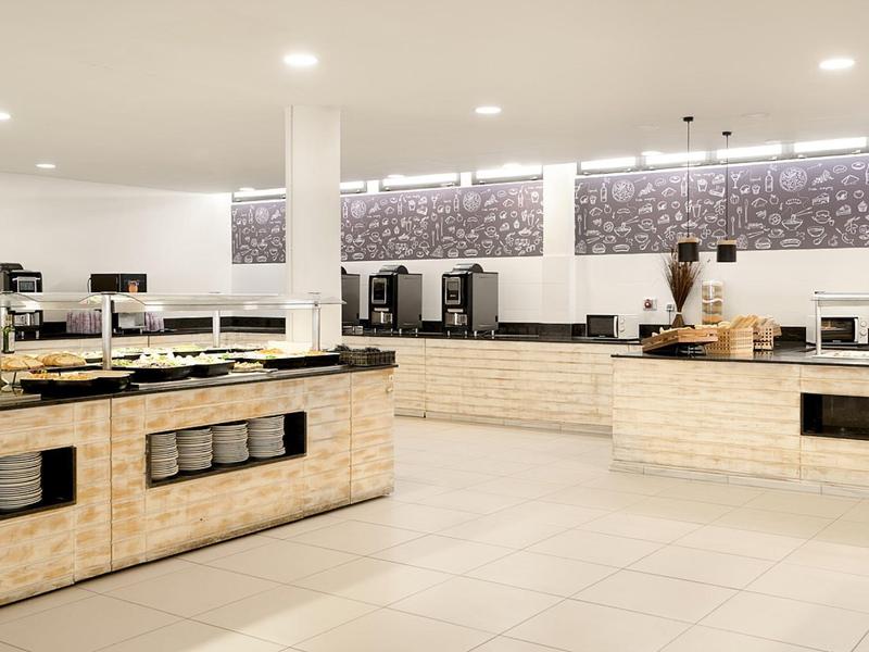 Buffet moderno dell'hotel con banconi in pietra chiara e illuminazione luminosa.