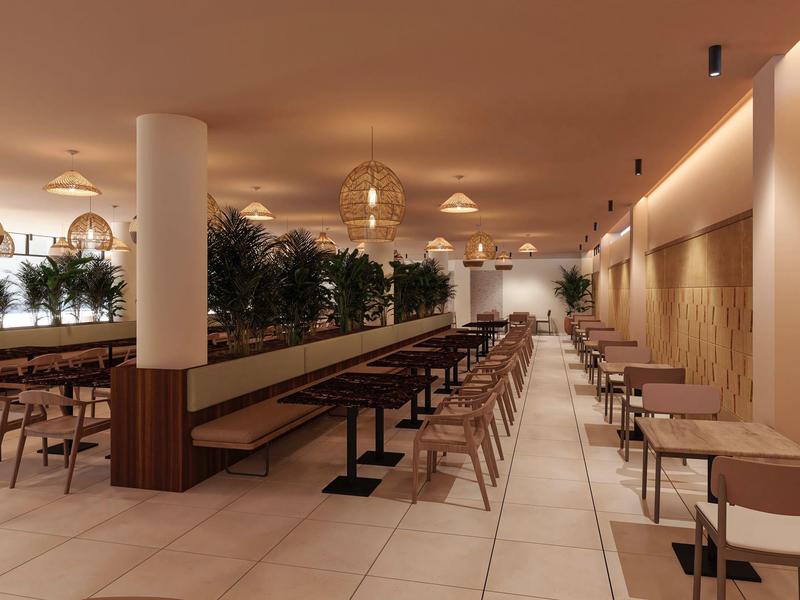 Ampia sala ristorante con tavoli in legno, sedie e piante decorative.