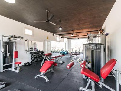 Modern gym with red upholstery, weights, and fitness equipment in a bright room.