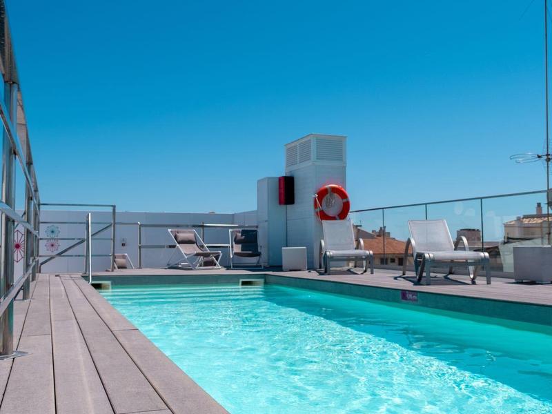 Nowoczesny basen na tarasie z widokiem na miasto pod czystym niebem.