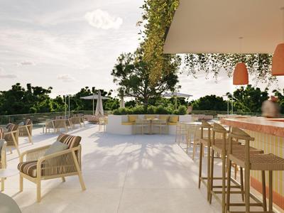 Area esterna moderna con bar, sedie e tavoli all'aperto con vista sul verde.