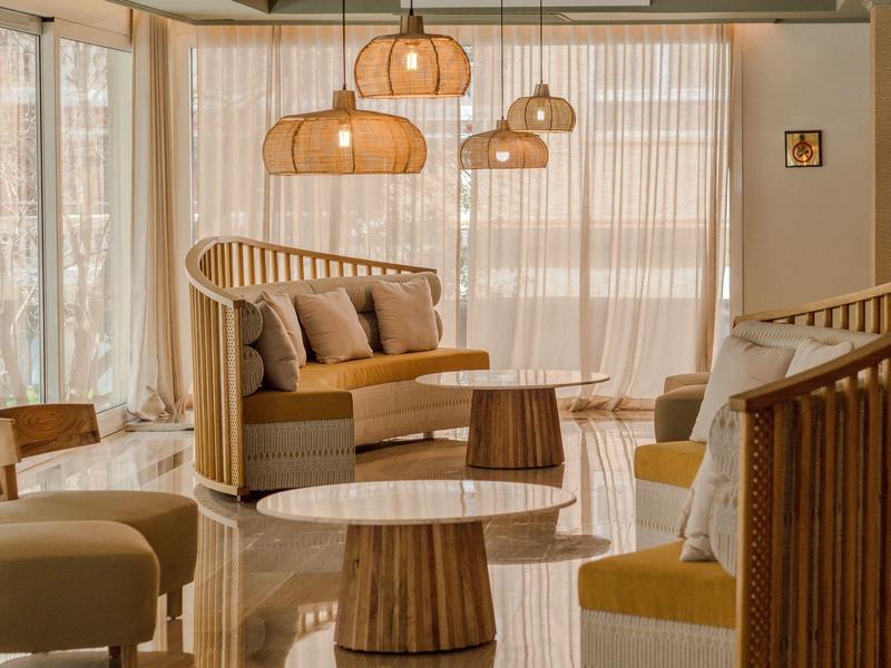 Pohodlná sezení s dřevěným nábytkem a teplým osvětlením před velkými okny.