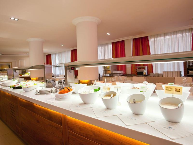 Bufet s různými předkrmy a saláty v světlé jídelně.