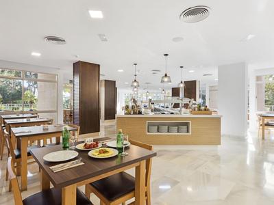 Ristorante luminoso con mobili in legno e area buffet dal design moderno.