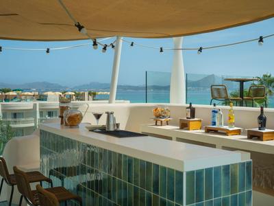 Bar moderna dell'hotel sulla terrazza con vista sul mare e cielo azzurro.