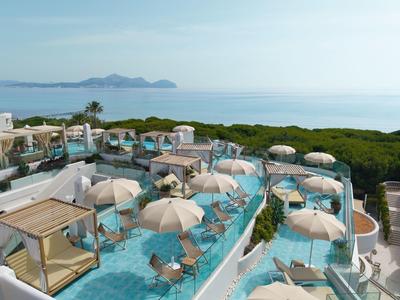 Terrazza sul tetto con ombrelloni, lettini e vista mare con cielo sereno.