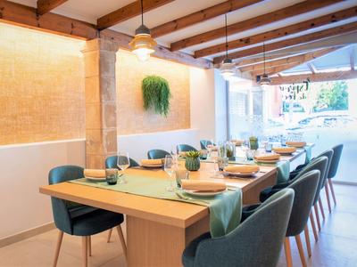 Área de comedor moderna con techo de madera, mesa larga y elegantes sillas azules en restaurante del hotel.