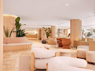 Área luminosa y moderna de salón de hotel con asientos cómodos y plantas.