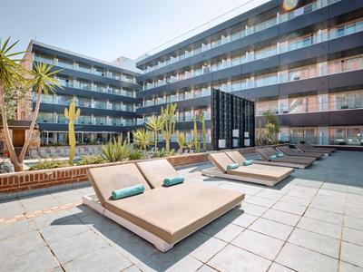 Moderner Innenhof mit Liegestühlen, Pflanzen und Glasbalkonen an einem großen Wohngebäude.