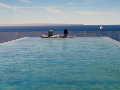 Ein Infinity-Pool mit klar blauem Wasser, zwei Personen und Segelboot im Hintergrund am Meer.