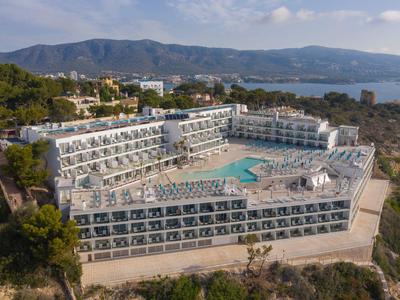 Velký hotel na útesu s bazénem a výhledem na moře a okolní hory.