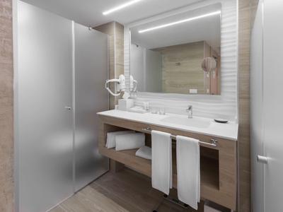 Moderní koupelna s dvojumyvadlem, velkým zrcadlem a skleněným sprchovým koutem.