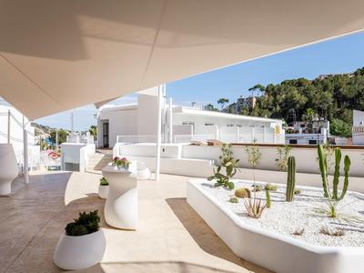 Nowoczesne lobby hotelowe z białymi meblami i roślinami przy słonecznej pogodzie.