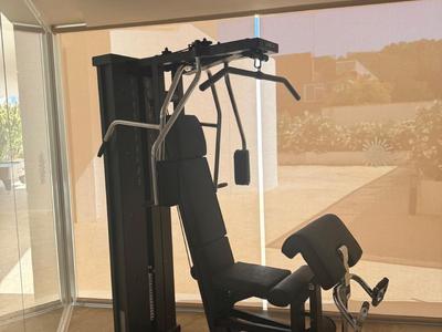 Modern fitness machine in a bright room with large windows overlooking a landscape.
