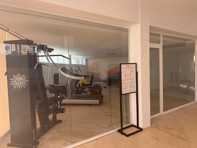 Fitness room with exercise equipment in a modern hotel area.