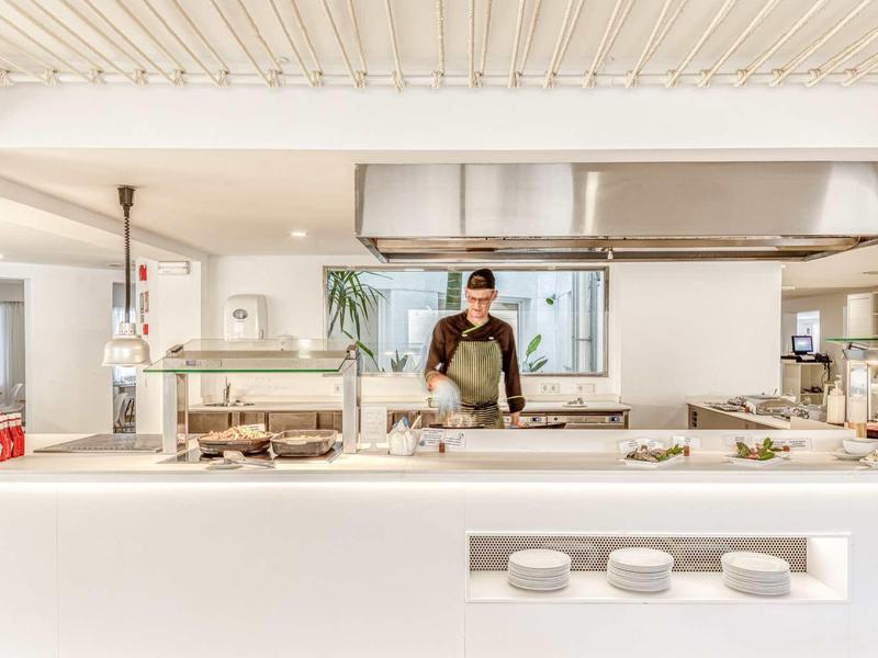 Nowoczesna kuchnia hotelowa z kucharzem, czysta i dobrze oświetlona