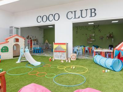 Aire de jeux pour enfants avec structures d'escalade, tunnel, toboggan et jouets colorés dans un hôtel.