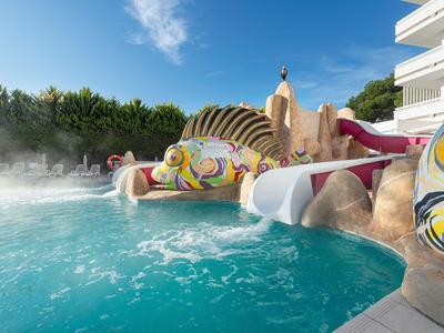 Piscina con scivoli d'acqua colorati e ospiti che si rilassano in una giornata di sole.