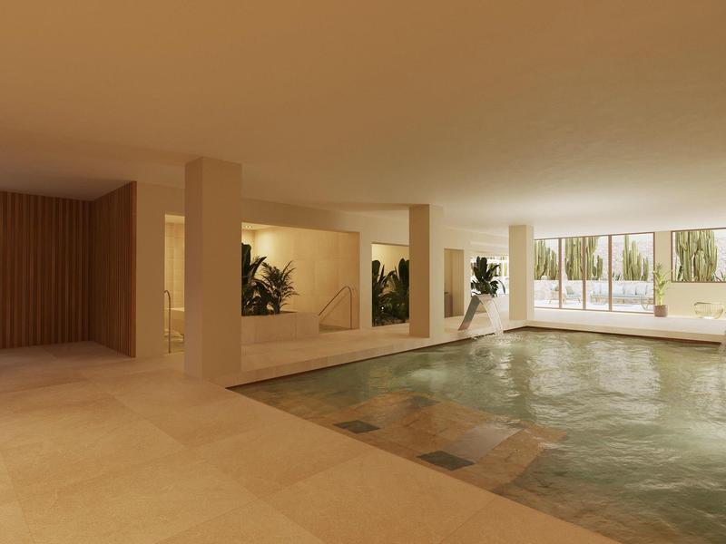 Moderner Innenpool mit großen Fenstern, beige Fliesen und Pflanzen im eleganten, offenen Raum.