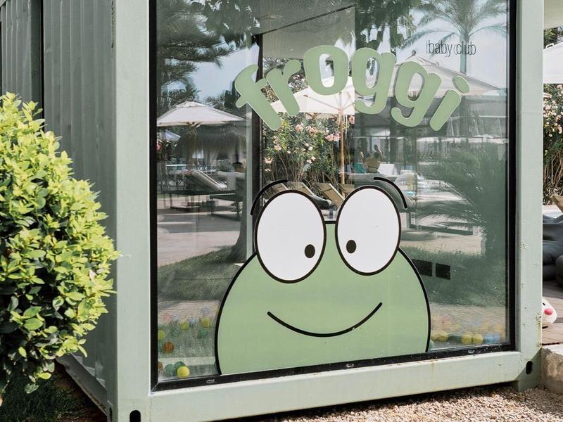 Grauer Container mit großer Glasscheibe, darauf grüner Frosch und Schriftzug "Lehrer".