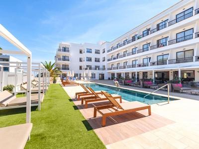 Zone de piscine d'hôtel moderne avec chaises longues et bâtiment à plusieurs étages sous un ciel bleu.