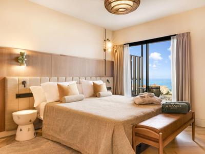 Camera d'hotel moderna con letto matrimoniale, vista mare e balcone