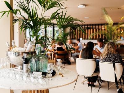 Elegante bar dell'hotel con bottiglie di champagne e ospiti sullo sfondo