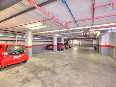 Lichte ondergrondse parkeergarage met meerdere geparkeerde auto's langs de muren