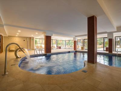 Area interna con piscina riscaldata e vasca idromassaggio in un hotel
