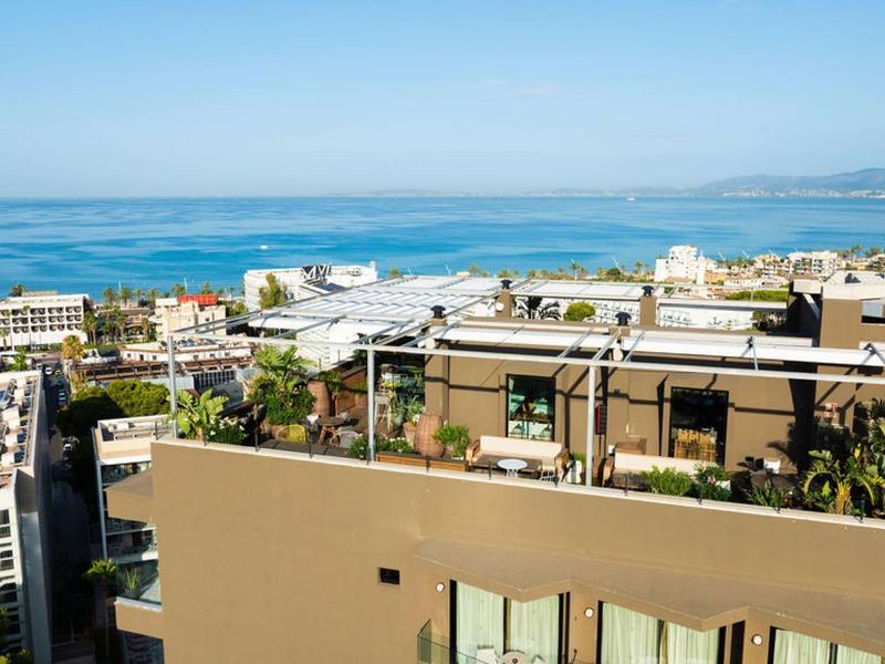 Vista su una città costiera con edifici moderni e cielo azzurro limpido.