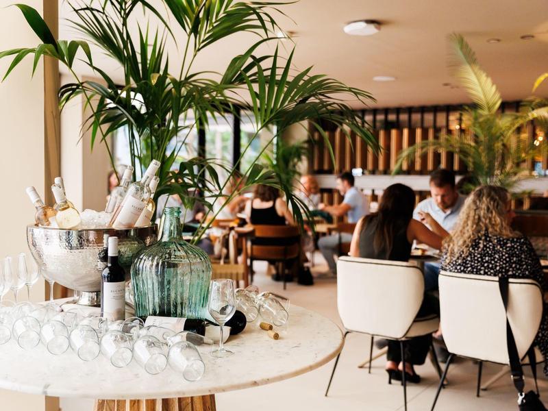 Elegante bar dell'hotel con bottiglie di champagne e ospiti sullo sfondo