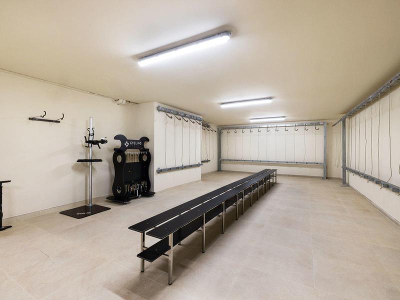 Ampia stanza luminosa con panchine e rastrelliere per biciclette in un hotel.