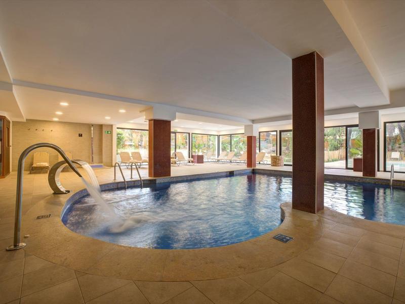 Area interna con piscina riscaldata e vasca idromassaggio in un hotel