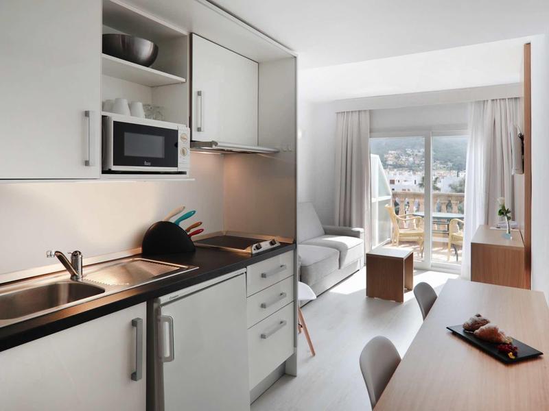 Cucina e soggiorno moderni e luminosi con balcone e vista sulle montagne.