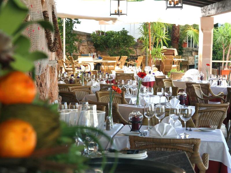 Terrazza di un ristorante con tavoli apparecchiati e vista su un giardino