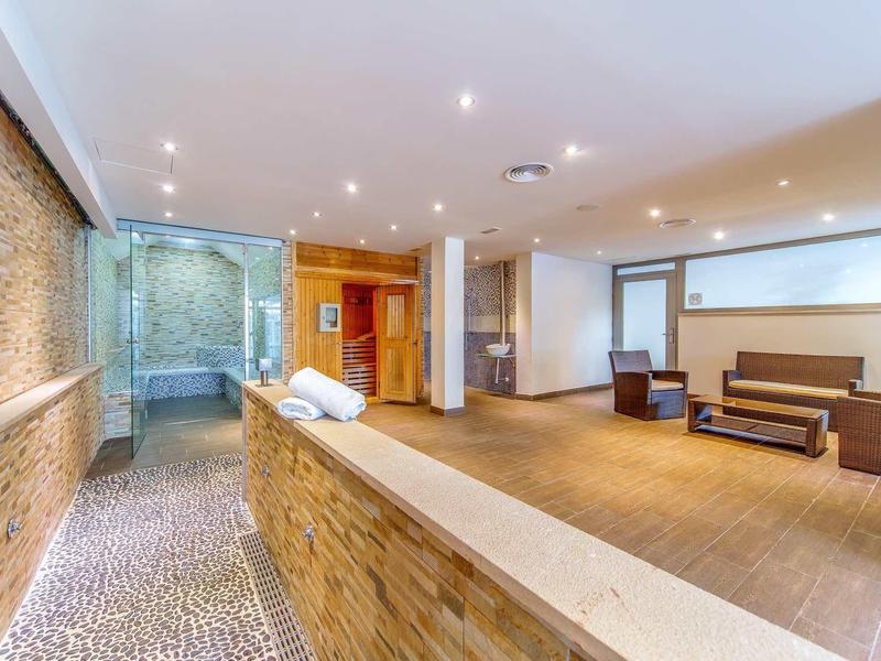 Moderner Eingangsbereich mit Steinboden, hellem Holz, Sofa und indirekter Beleuchtung.