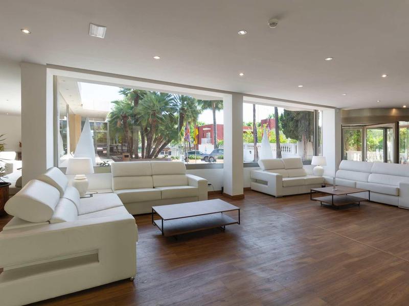 Helles Wohnzimmer mit weißen Ledersofas, Holzboden, großem Fenster und modernem minimalistischen Stil.