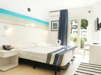 Camera luminosa con letto matrimoniale, balcone e arredamento marittimo moderno.