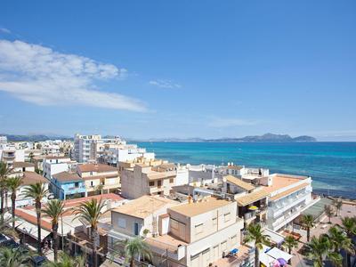 Widok miasta z hotelami, palmami i niebieskim morzem pod czystym niebem.