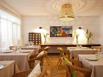 Sala ristorante luminosa con tavoli apparecchiati, mobili in legno e arte murale in stile moderno.