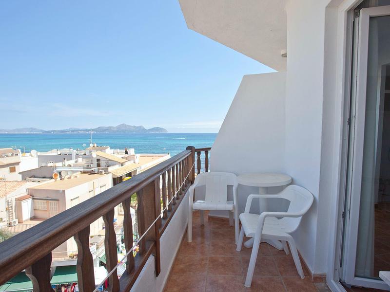 Balkon z białym stołem i krzesłami z widokiem na morze i niebieskie niebo