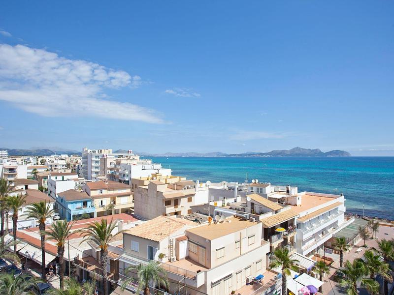 Widok miasta z hotelami, palmami i niebieskim morzem pod czystym niebem.