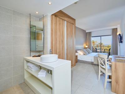 Habitación de hotel moderna con cama doble, escritorio y gran ventana con vista.