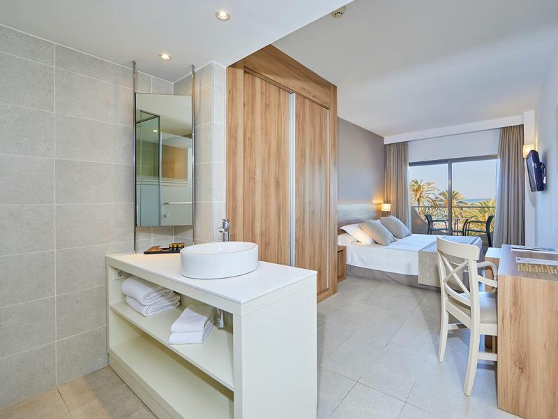 Habitación de hotel moderna con cama doble, escritorio y gran ventana con vista.