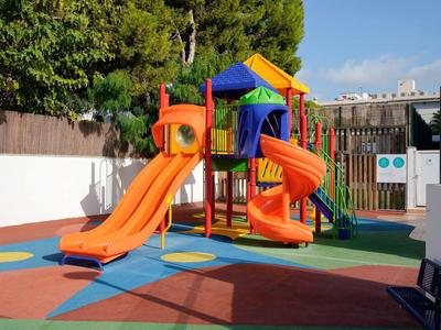 Parco giochi colorato con scivoli su pavimento morbido in gomma all'aperto.