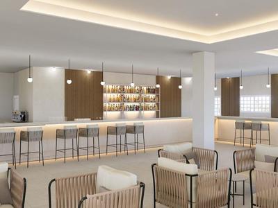 Nowoczesny hotelowy salon z eleganckimi miejscami do siedzenia i długim barem z hokerami.