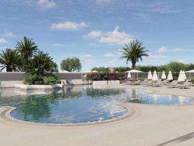 Okrągły basen na zewnątrz z leżakami i palmami pod niebieskim niebem