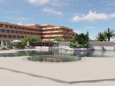 Complejo hotelero moderno con piscina, áreas para sentarse y palmeras bajo un cielo azul.